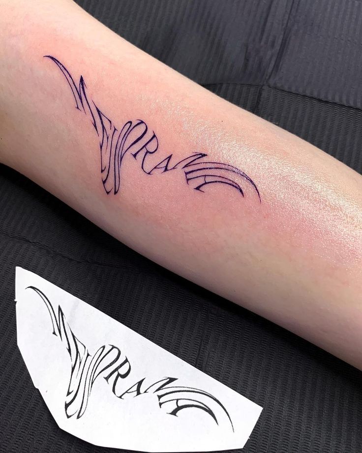 a person with a tattoo on their arm that has the word love written in cursive writing