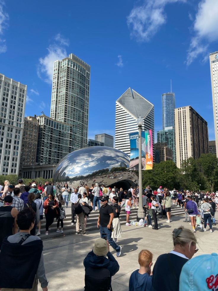 many people are walking around in the city with tall buildings and skyscrapers behind them