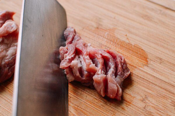 the meat is being cut into pieces with a knife