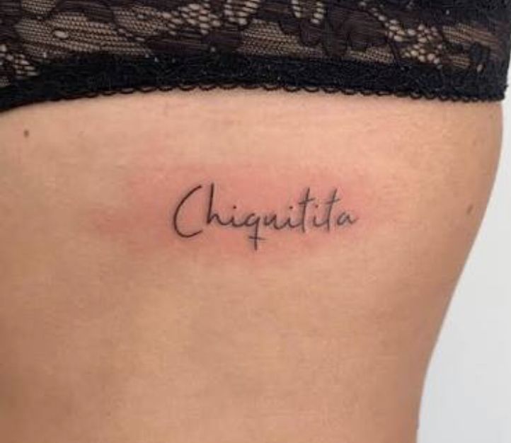 a woman's stomach with the word chiquita tattooed on her lower back