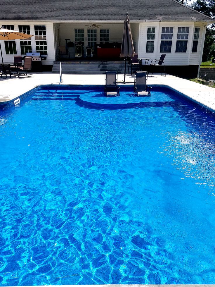 an empty swimming pool in front of a house