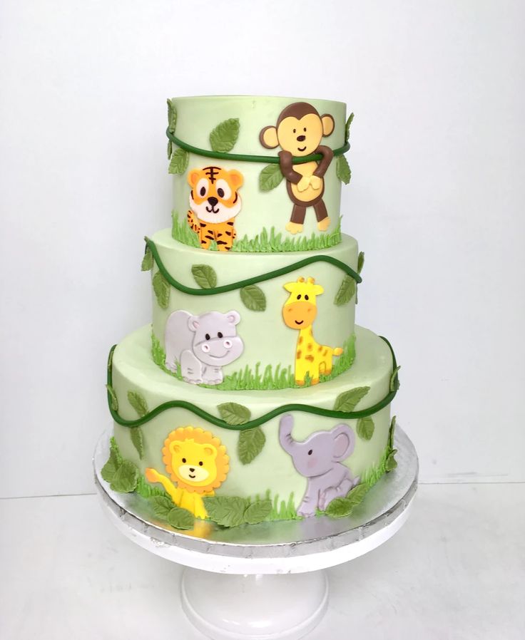 a three tiered cake decorated with jungle animals