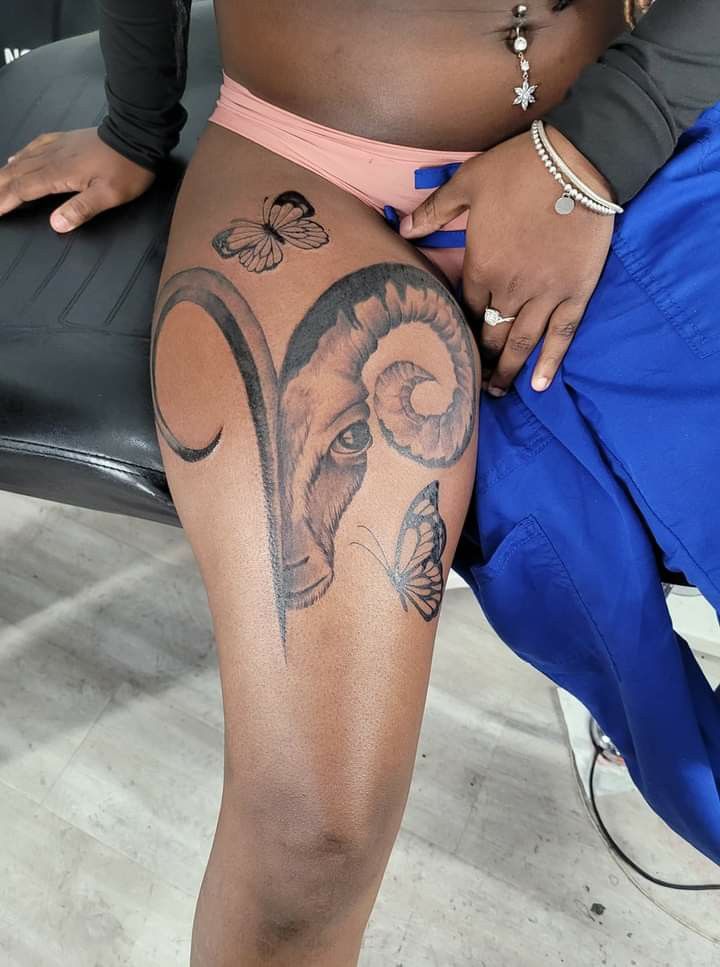 a woman with tattoos on her legs sitting in a chair