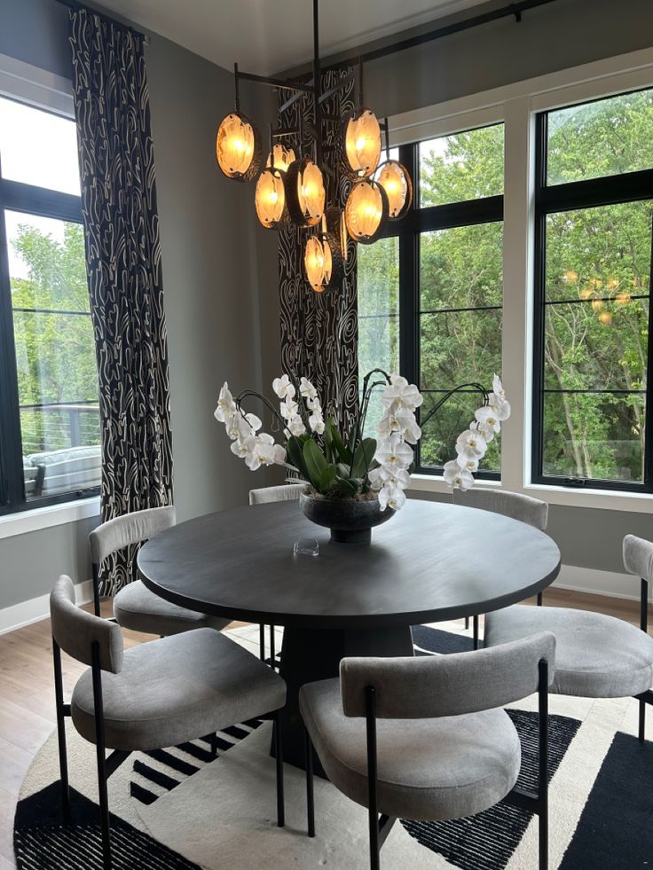 a dining room table surrounded by chairs and flowers