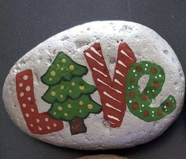 two rocks with christmas decorations on them and the word love painted on one rock next to each other