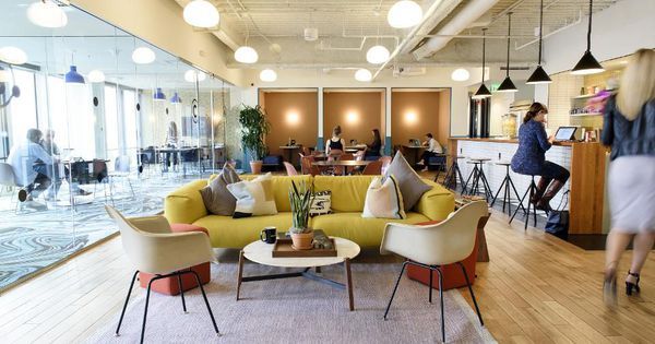 a yellow couch sitting in the middle of a living room next to a table and chairs