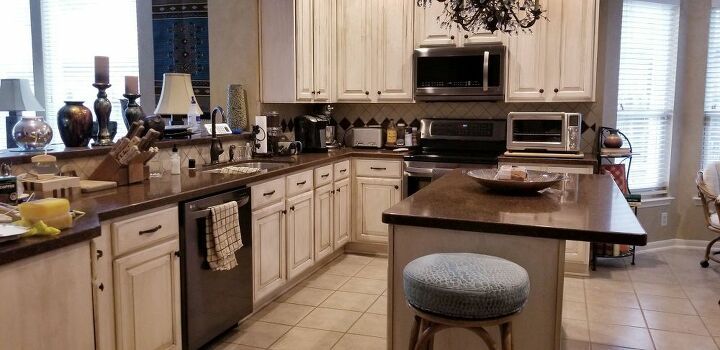 a kitchen with white cabinets and stainless steel appliances, along with a breakfast nook