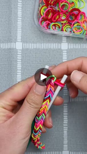 a person holding a pen and some colorful bracelets