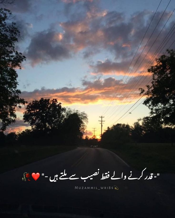 the sun is setting over an empty road with trees and power lines in the background