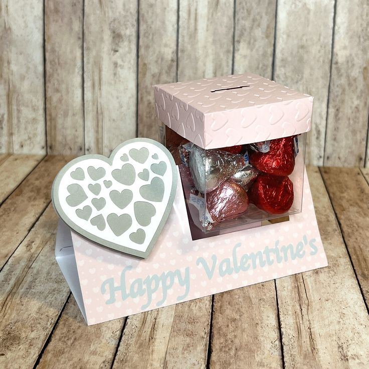 a valentine's box filled with chocolates on top of a wooden table