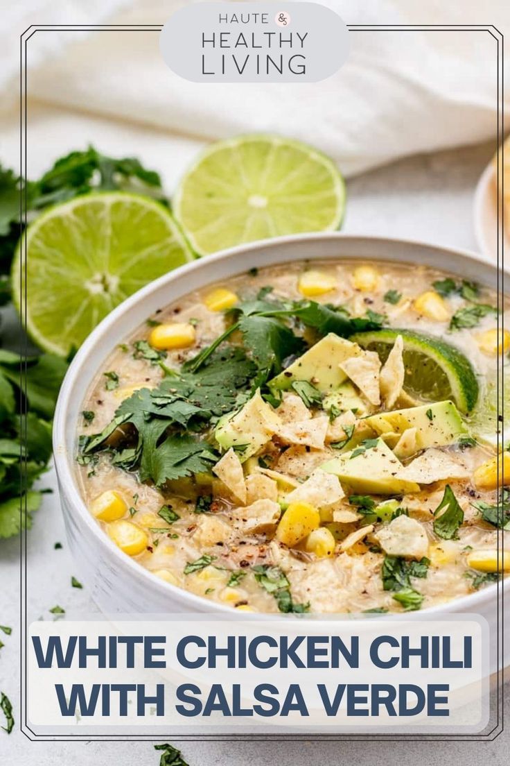 a white bowl filled with corn and tortilla soup next to lime wedges