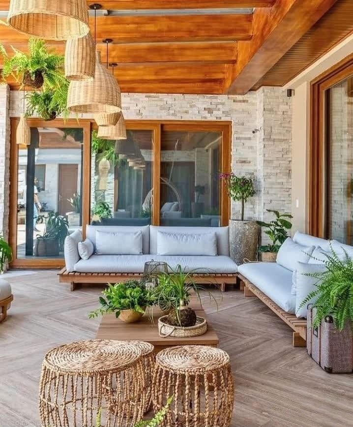 an outdoor living area with wicker furniture and potted plants