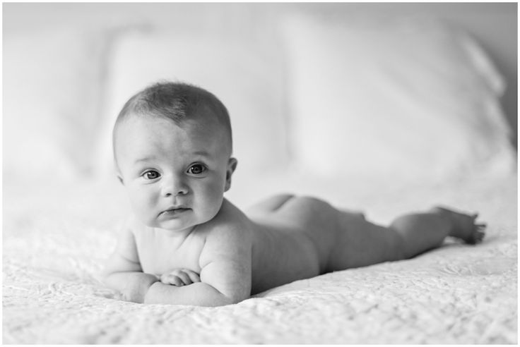 a baby laying on its back in black and white