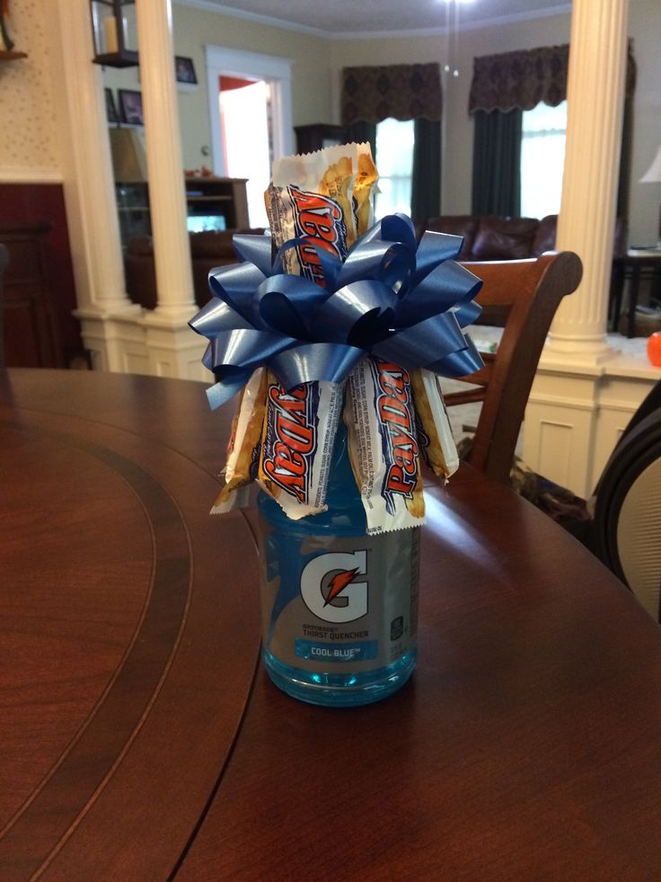 an image of a bottle with candy wrapped in blue and white ribbon sitting on top of a table