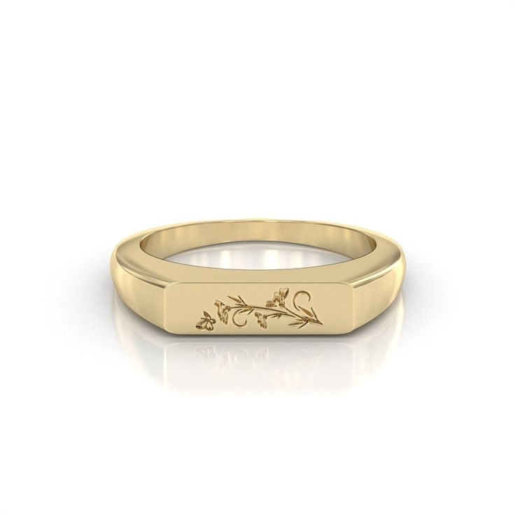 a yellow gold signet ring with an engraved design