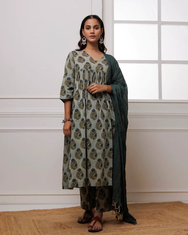 Experience luxury and elegance in our Forest Green Block Printed Suit Set. Crafted from fine mul-mul, this set showcases a classic traditional block print in a deep forest green hue. The set also includes a beautifully complementing dupatta adorned with delicate bead work along its edges. Elevate your wardrobe with this exclusive and timeless piece. No. of pieces - 3 piece set. Color - Green. Fabric - Mul-Mul, Cotton. Washing Instructions - Dry Clean. Elegant Green Unstitched Suit For Transitional Season, Formal Cotton Kurta With Printed Motifs, Elegant Cotton Sets For Diwali, Traditional Green Lawn Suit For Formal Occasions, Elegant Long Sleeve Block Print Sets, Festive Dark Green Sets, Traditional Green Anarkali Set With Block Print, Traditional Green Formal Lawn Suit, Green Unstitched Suit With Printed Motifs For Diwali