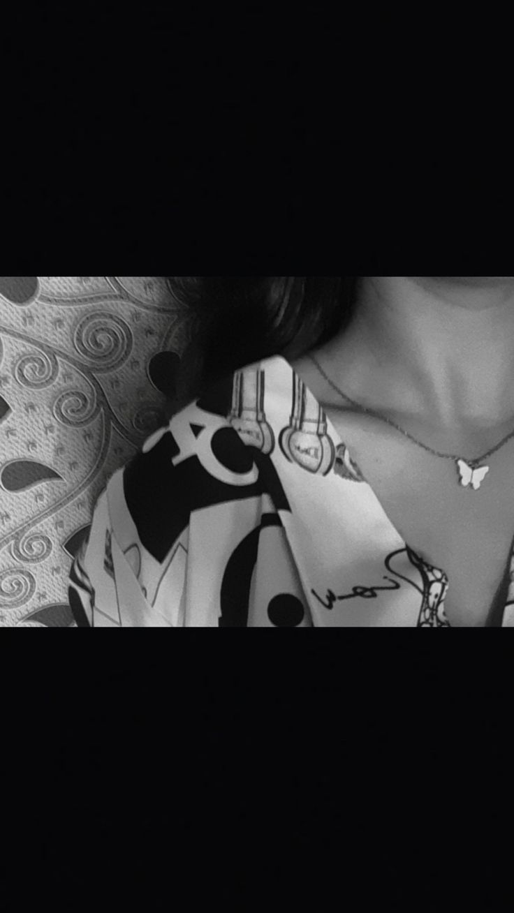 black and white photograph of a woman's neck wearing a shirt with hearts on it