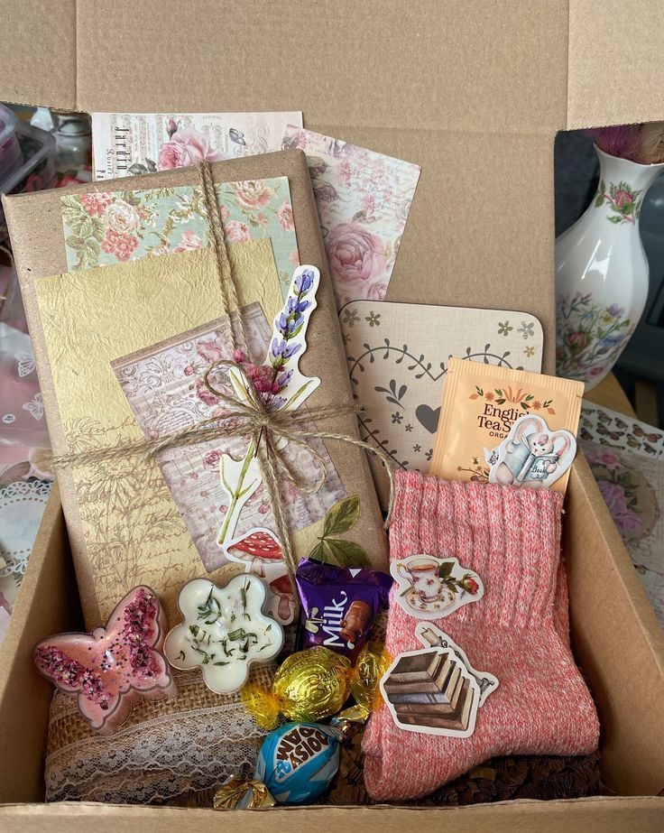 a box filled with lots of assorted items on top of a table next to a vase