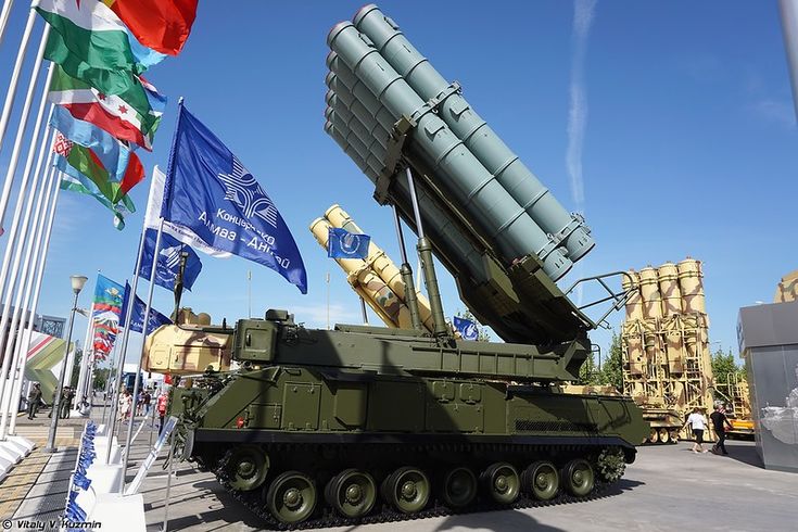 an army vehicle with missiles on it in front of flags