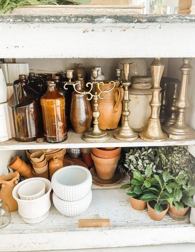 pots and vases are sitting on shelves in an old cabinet, with plants growing out of them