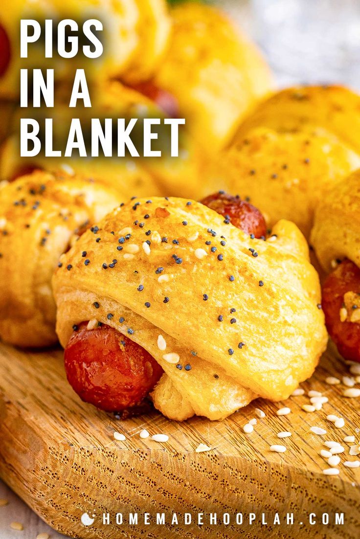 pigs in a blanket on a cutting board with sesame seeds and pepper sprinkles