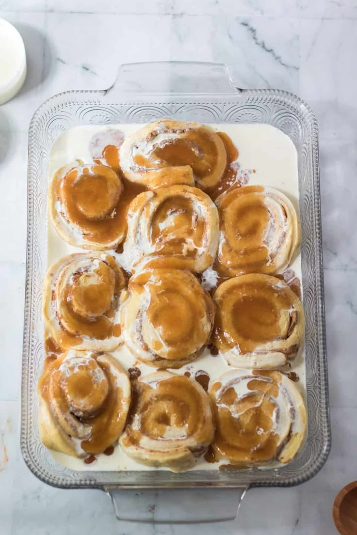 cinnamon rolls with icing in a glass baking dish