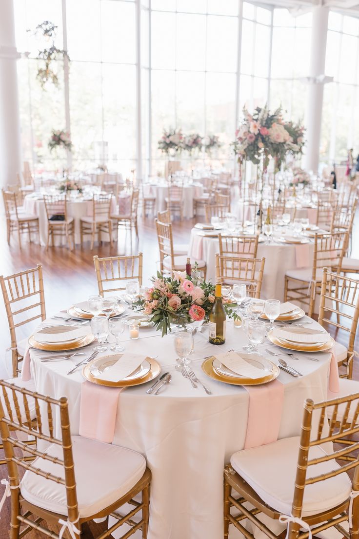 the tables are set with gold chargers and white linens for an elegant wedding reception