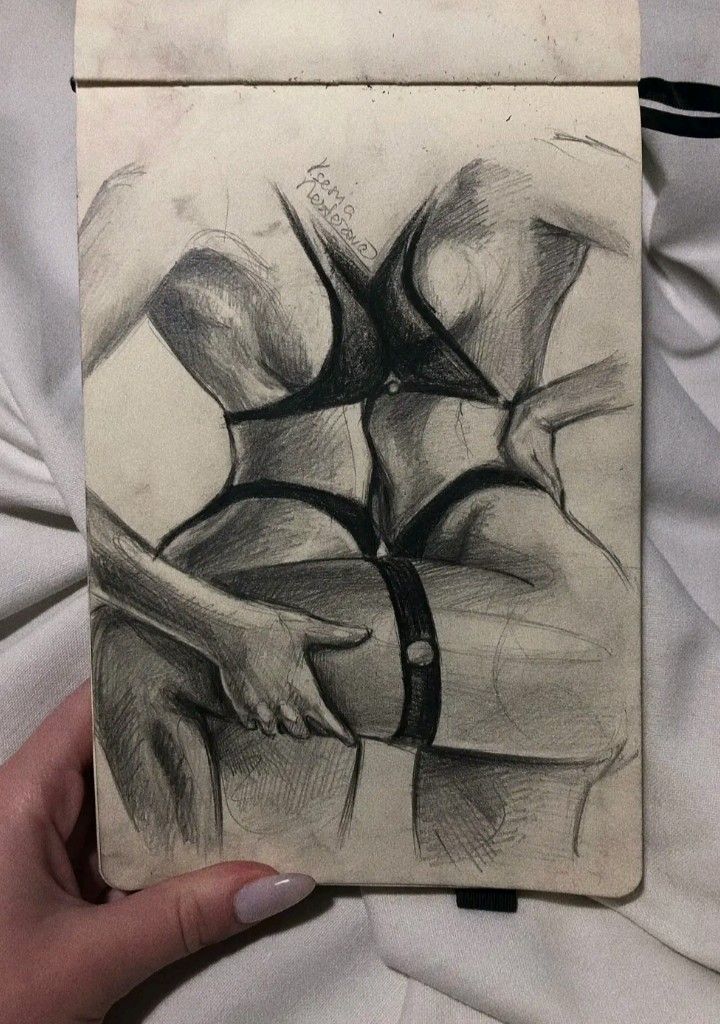 a pencil drawing of a woman's torso on a piece of paper in her hand