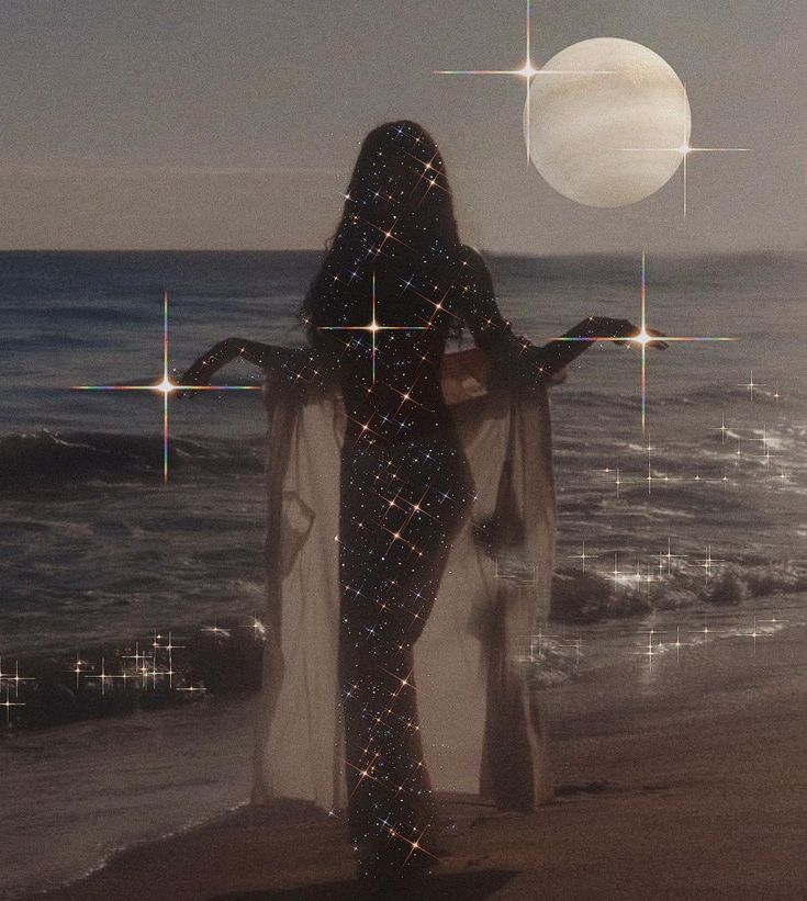 a woman standing on top of a beach next to the ocean under a full moon