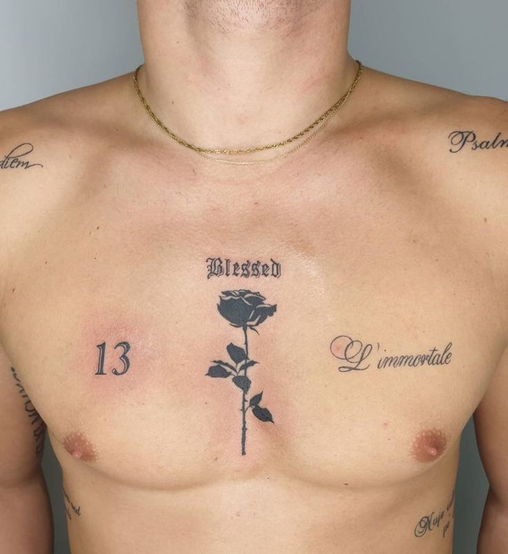 a shirtless man with tattoos on his chest holding a rose and the number 13