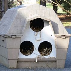 a bird house made out of concrete with two birds in it