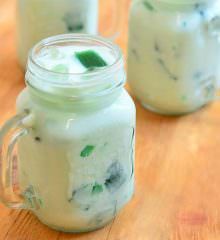 two mason jars filled with green liquid on top of a wooden table