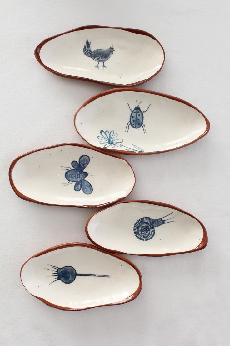 four plates with bugs on them sitting next to each other in front of a white background