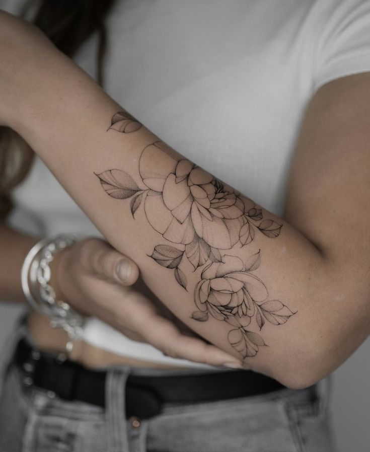 a woman with a flower tattoo on her arm