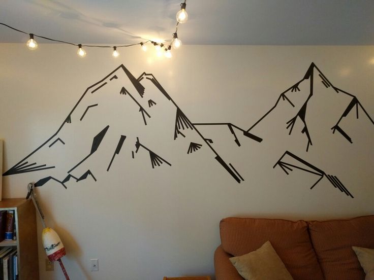 a living room with mountains painted on the wall and string lights hanging from the ceiling