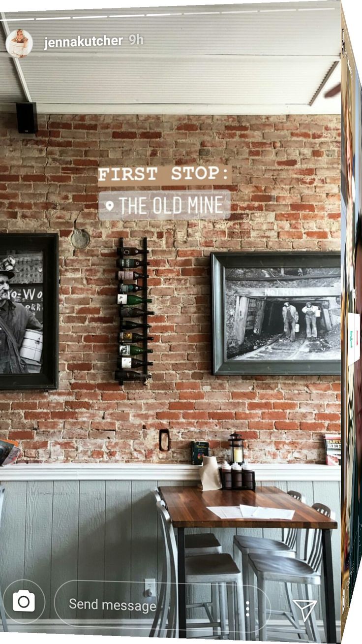 the interior of a restaurant with brick walls and pictures hanging on the wall above it