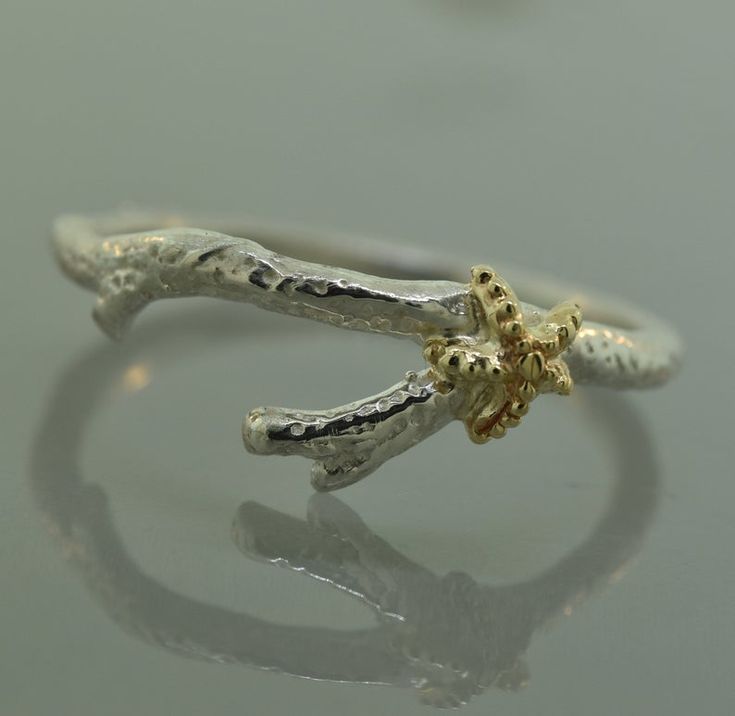 a silver and gold ring with two branches