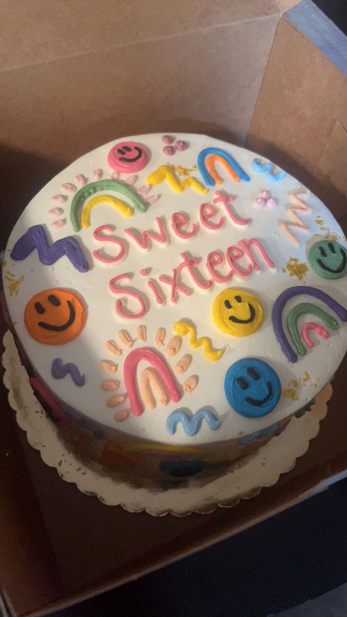 a birthday cake in a box with the words sweet sixteen on it and smiley faces