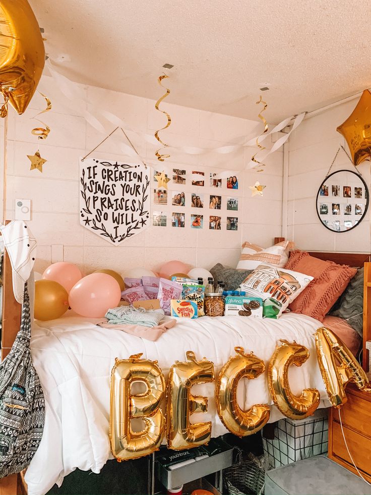 a bed room with balloons and pictures on the wall, some gold foil letters hanging from the ceiling