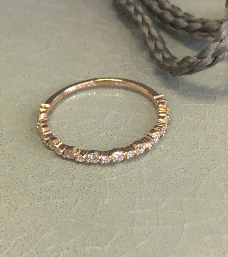 a gold ring sitting on top of a table next to a rope and some beads