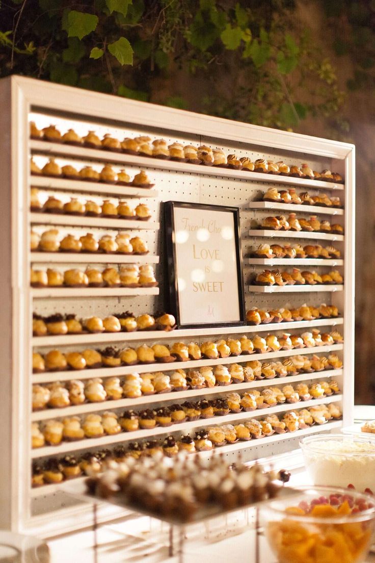 there are many pastries on display in the buffet area at this wedding reception, including donuts and cupcakes