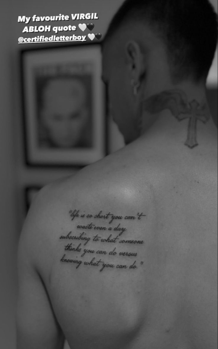 the back of a man's shoulder with a tattoo saying, my favorite virgil