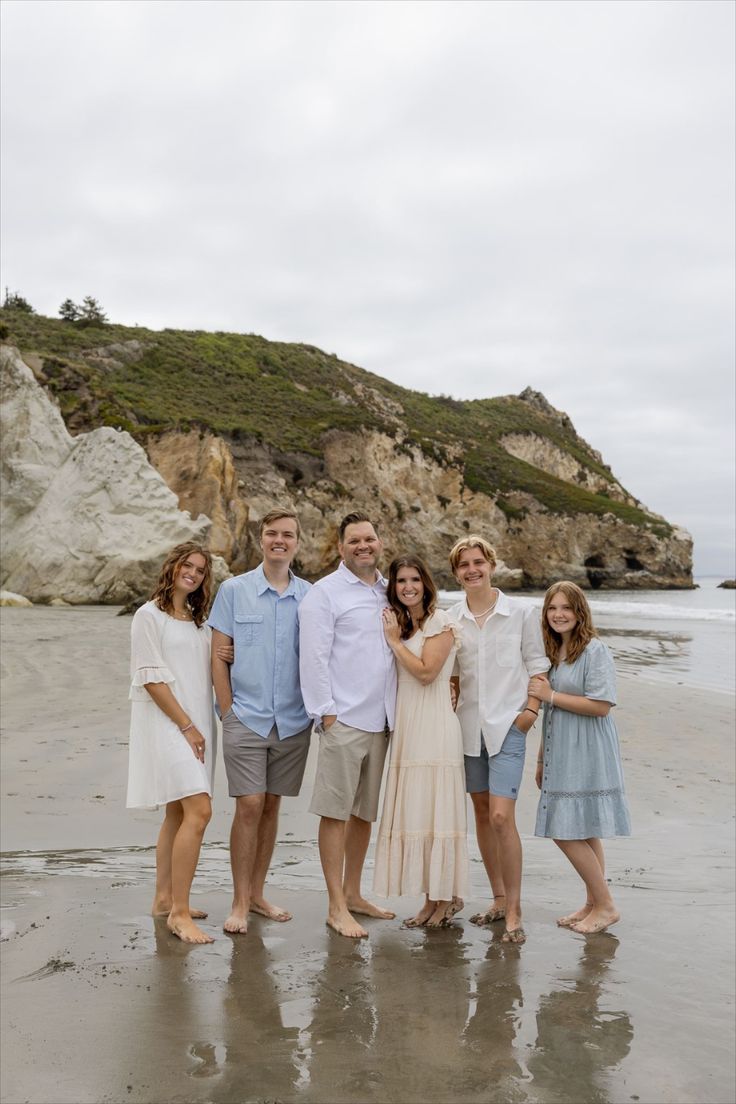 a group of people standing next to each other on a beach