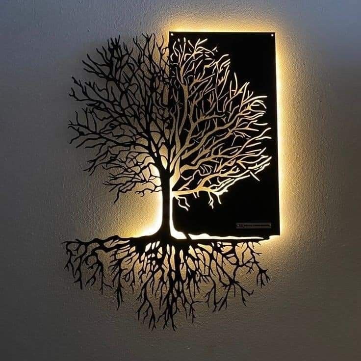 a wall mounted light with a tree on it