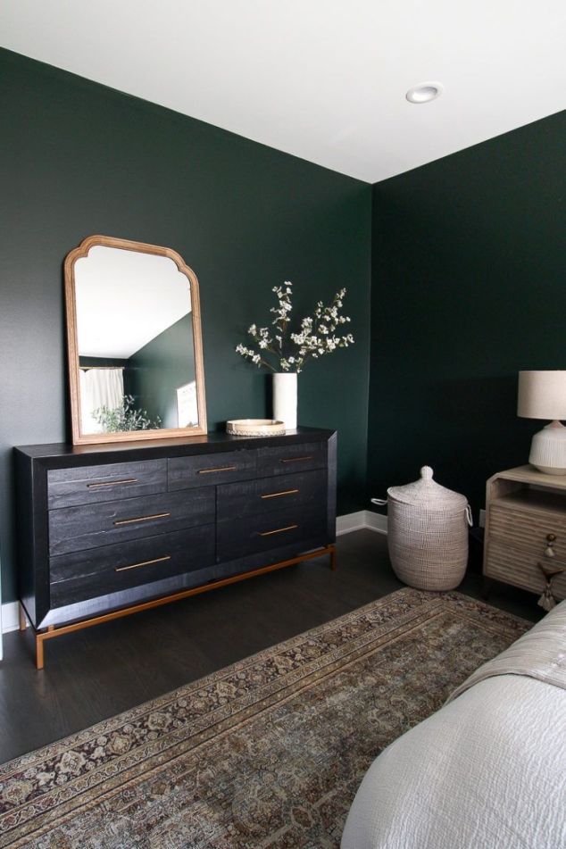 a bedroom with dark green walls and white furniture