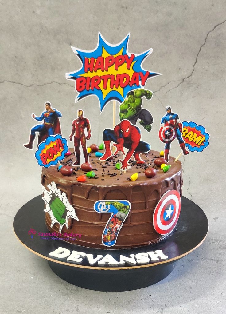 the birthday cake is decorated with superhero characters