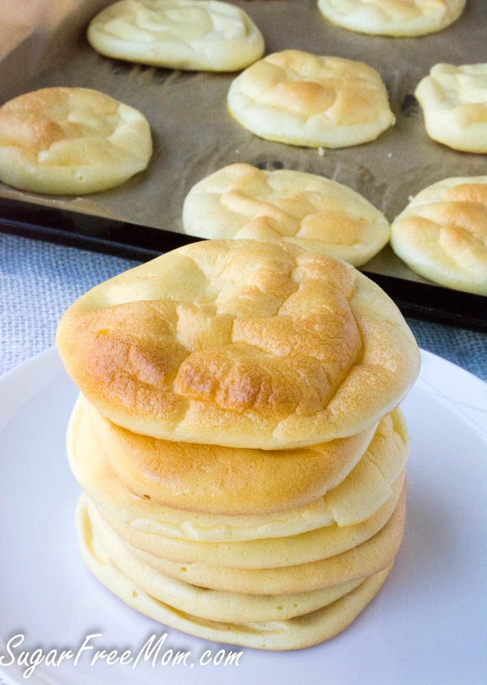 a stack of bread rolls sitting on top of a white plate next to a muffin tin