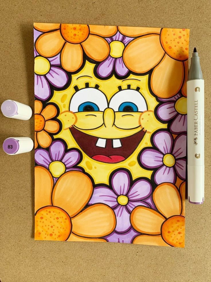 a drawing of a cartoon character with flowers on it and two markers next to it