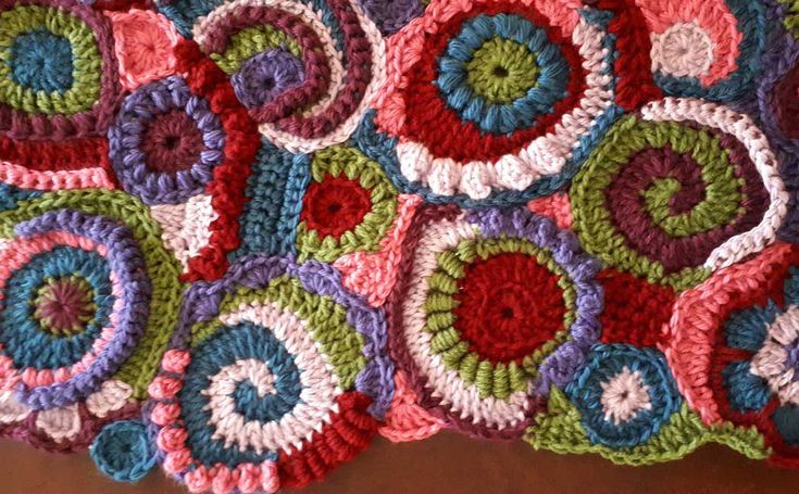 a crocheted blanket is laying on the floor