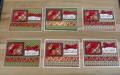 four christmas cards with bows and ribbons on them, sitting on a wooden table top